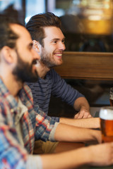 happy male friends drinking beer at bar or pub