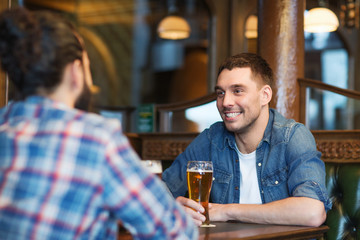 happy male friends drinking beer at bar or pub