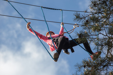 Girl climbing in adventure park , rope park     © wip-studio