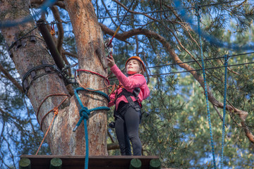 Girl climbing in adventure park , rope park     © wip-studio