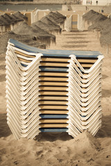 Stacks of loungers and thatched umbrellas on a sandy beach of Es