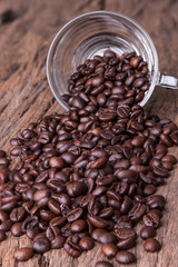 Cup full of coffee beans on wood