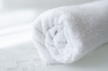 folded clean white bath towel on table
