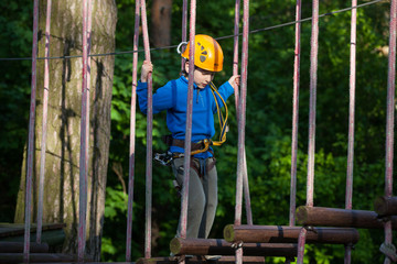 boy  climbing in adventure park,  rope park