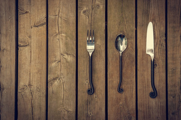 Cutlery - Fork, Spoon and Knife on Wooden Background