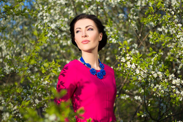 portrait of young beautiful woman in garden with blooming trees