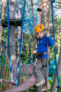 boy  climbing in adventure park,  rope park