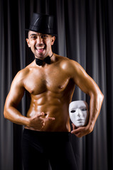 Muscular actor with theatrical mask