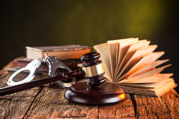 Wooden gavel and books on wooden table - obrazy, fototapety, plakaty