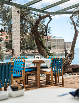 Tables at seaside restaurant with beautiful view on the island Saint Stephen in Montenegro