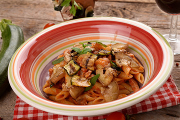 Penne with tomato sauce with bacon, zucchini and eggplants