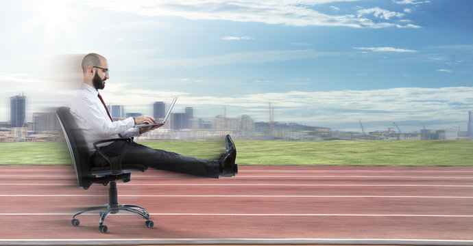 Fast Business - Businessman Sitting With Laptop Runs On Track
