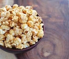 Golden Caramel Popcorn in a Bowl on a wooden table