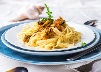 Pasta with mussels with tomatoes and arugula.