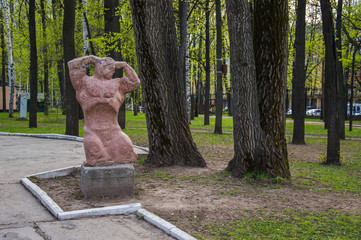 каменная скульптура с изображением мускулистого мужчины в парке