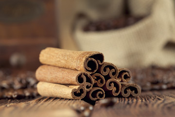 Obraz na płótnie Canvas Cinnamon sticks, coffee grains and old grinder