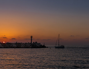 Sailing boat returning at sunset