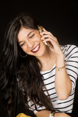 Happy brunette woman talking on her cell phone smiling looking d