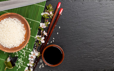 Obraz na płótnie Canvas Japanese sushi chopsticks, soy sauce bowl, rice and sakura bloss