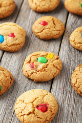 Cookies with colorful candy on grey wooden background