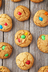Cookies with colorful candy on grey wooden background