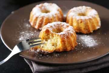 Bundt cakes on plate on black background