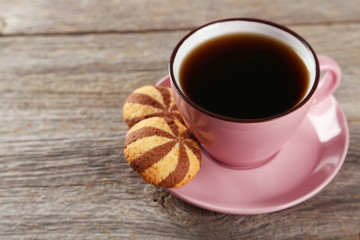 Cup of coffee with cookies on grey wooden background