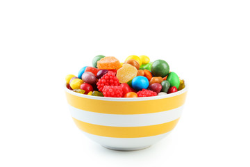 Colorful candies in bowl on white background