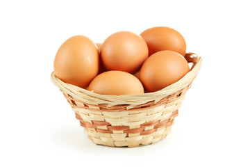 Chicken eggs in basket isolated on white