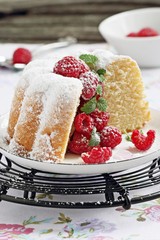 Bundt cake with fresh raspberries on a rustic dark background 