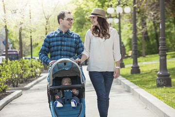 young family with baby strollers on city walk