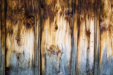 Wooden wall made of stained brown vertical battens.