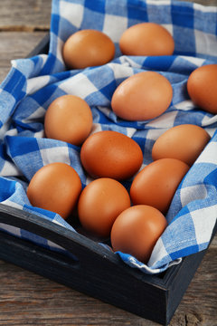 Chicken eggs in tray on grey wooden background