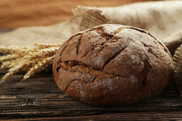 Freshly baked bread on brown wooden background