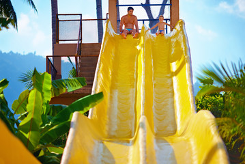 happy father and son are ready to slide in tropical aqua park