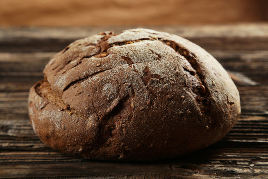 Freshly baked bread on brown wooden background