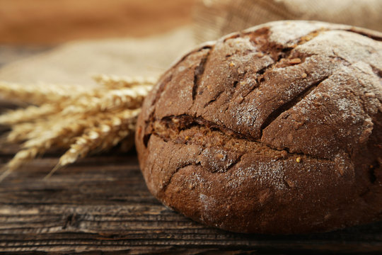 Freshly baked bread on brown wooden background