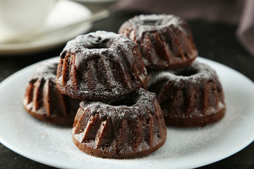Chocolate bundt cakes on plate on black background