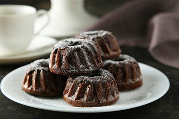Chocolate bundt cakes on plate on black background