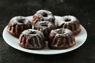Chocolate bundt cakes on plate on black background
