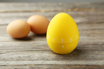 Yellow egg timer on grey wooden background