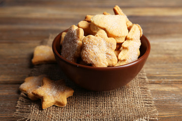Cookies in bowl on brown wooden background