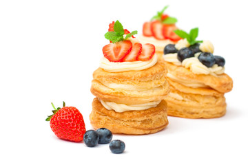 homemade puff pastry stuffed with cream and berries on white