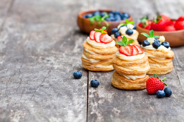 homemade puff pastry stuffed with cream and berries on the rusti