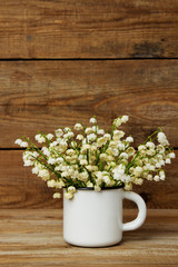 bouquet of lily of the valley in the white mug