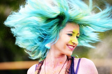 Beautiful girl twirls by head during Holi color festival
