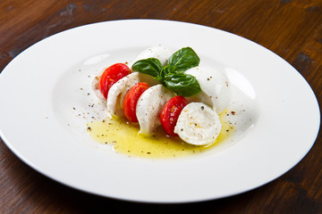fresh mozzarella with tomatoes and basil leaves