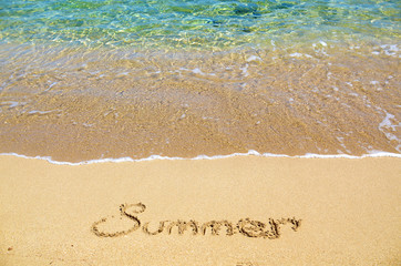 Fototapeta na wymiar Summer written on the sand