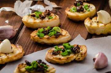 Mini toasts with garlic and dried tomato