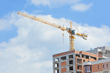 Crane and building construction site against blue sky
